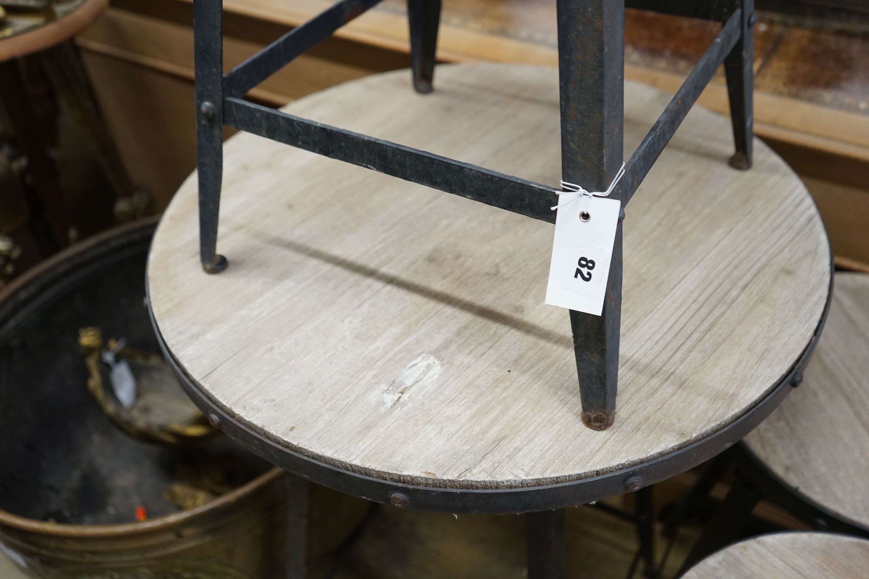 An industrial style circular adjustable table, diameter 60cm, together with three matching stools